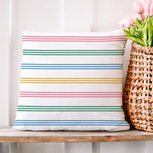 Load image into Gallery viewer, An Easter pillow cover sitting next to some pink tulips. The pillow cover features a pattern of colorful stripes in shades of pink, green, blue, and yellow. The design is printed on both sides of the cover and is visible from any angle. The cover is made from high-quality, durable fabric and features a convenient zipper closure. It measures 18&quot;x18&quot; and fits standard pillow inserts.
