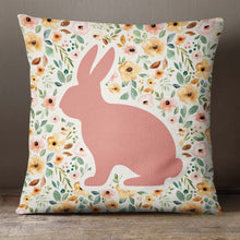 Load image into Gallery viewer, An Easter pillow cover featuring a spring floral pattern in pastel shades of pink, yellow, and green with a pink silhouette of a bunny. The design is printed on both sides of the cover. The cover is made from high-quality, durable fabric and features a zipper closure. It measures 18&quot;x18&quot; and fits standard pillow inserts.
